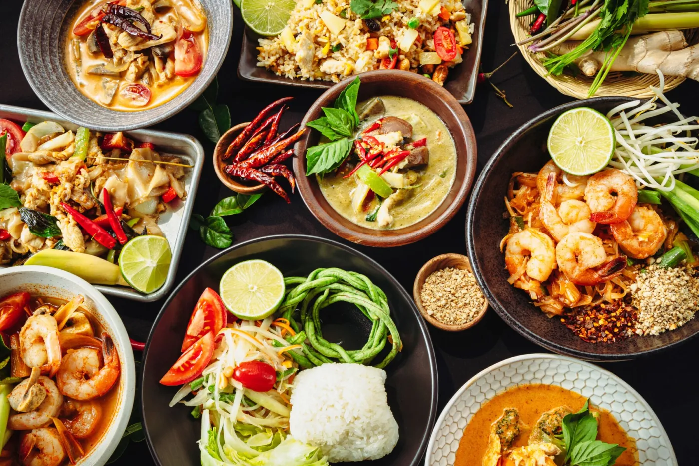 กับข้าวไทยหลายอย่างวางเต็มโต๊ะ ทั้งแกงเขียวหวาน ต้มยำ ผัดไทย ส้มตำ และข้าวสวย