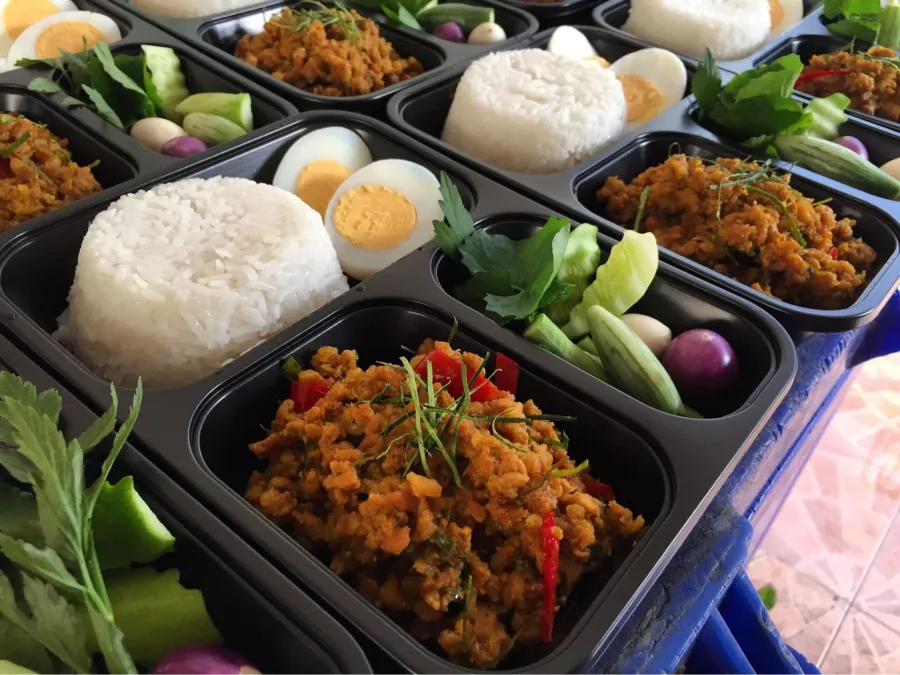 ข้าวกล่องหลายกล่องวางเรียง มีข้าวสวย กับข้าว ไข่ต้ม และผักเคียง